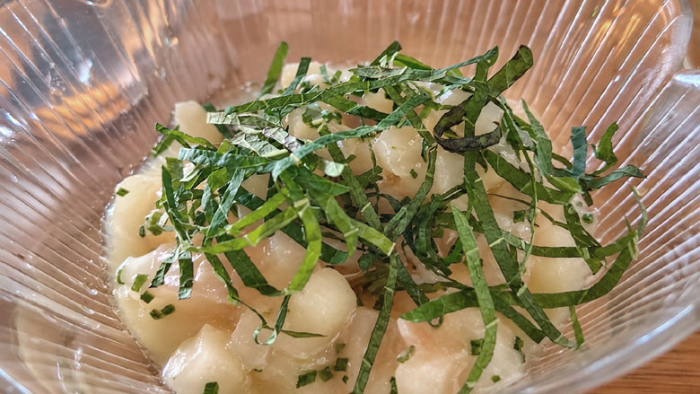 Ceviche lasikulhossa, päällä vihreitä yrttejä