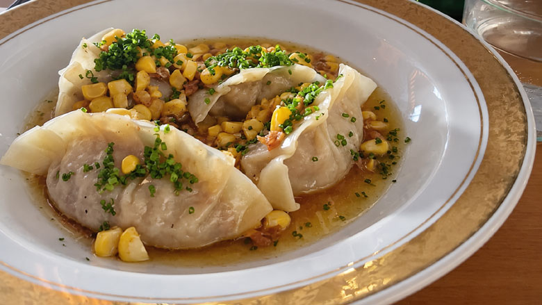 Sienidumplingit ja maissia vaalealla lautasella